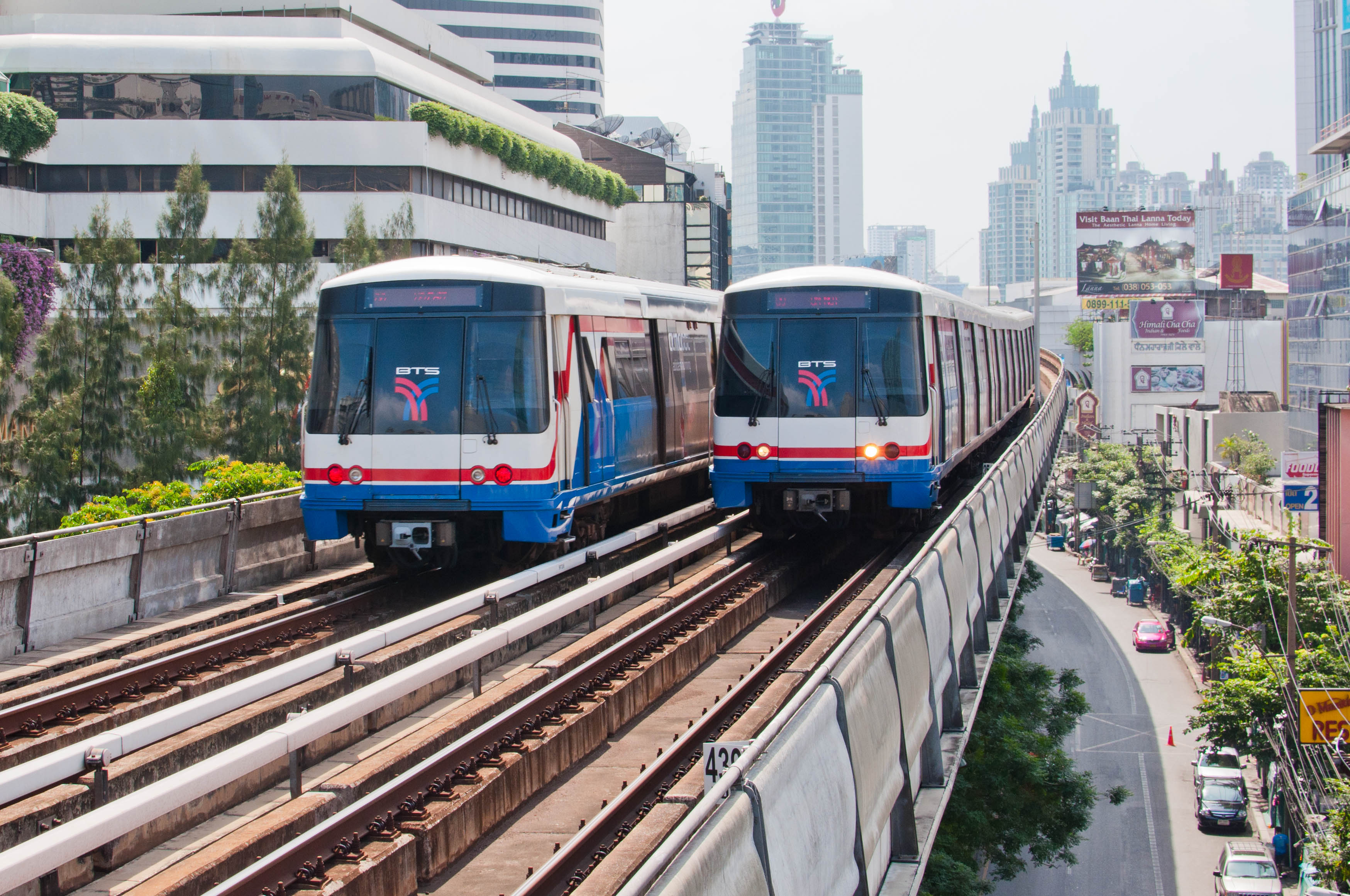 Two BTS SkyTrains pass each other at the Nana station on the Sukhumvit Line.